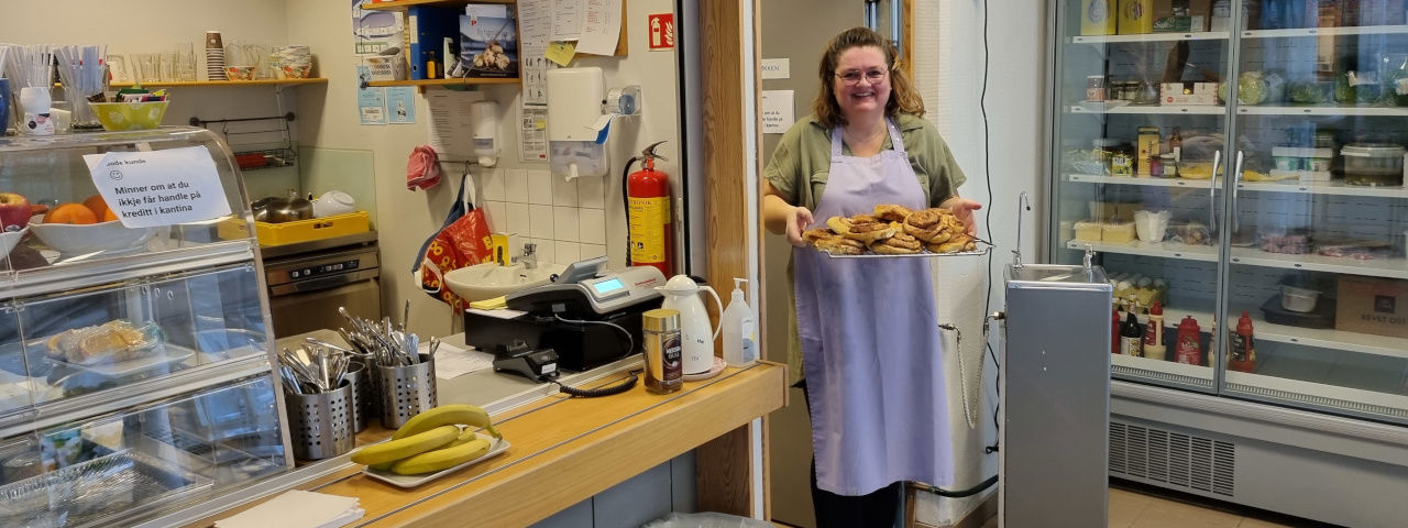 Kantinestyrar Trude Bode viser fram eit fat med nysteikte bollar. 